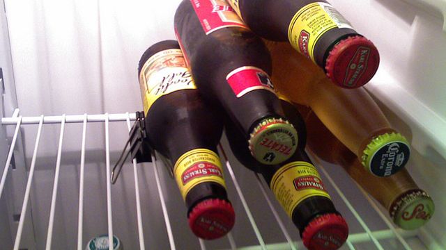Place binder clips on the rack of the fridge to keep bottles in place